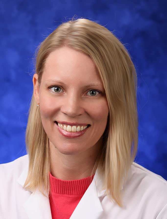 A portrait photograph of Dr. Amy Burns in front of a professional photo background.