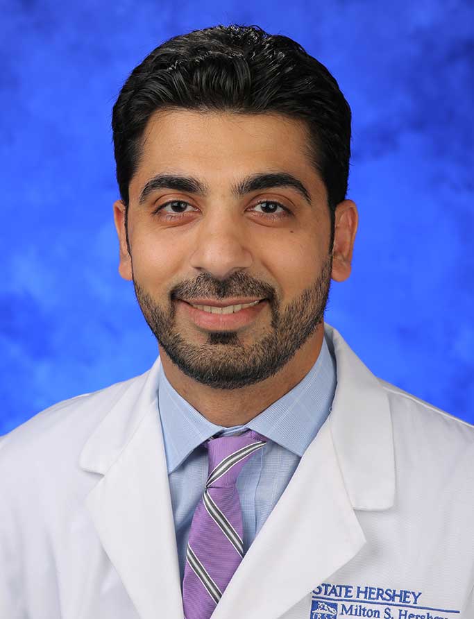 A portrait photograph of Dr. Usman Hameed in front of a professional photo background.